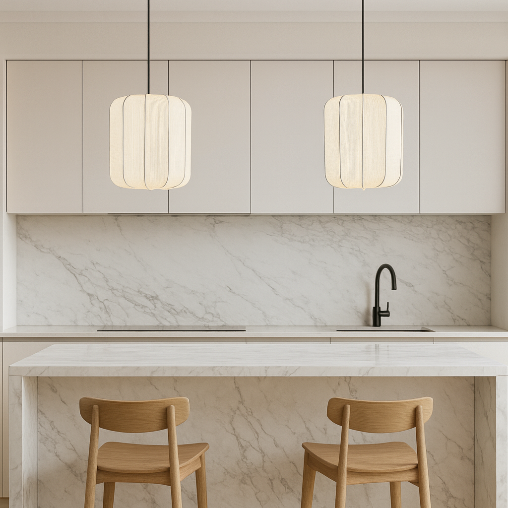 Modern kitchen with marble countertop, stools, and pendant lights.