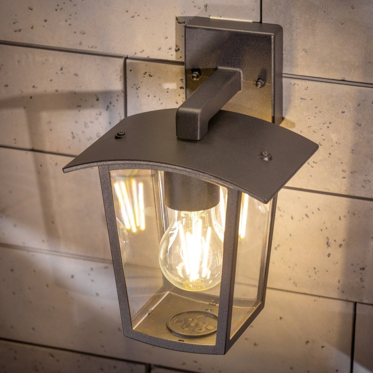 If you’re looking for a modern take on a traditional outdoor wall light, this black lantern wall light with clear diffuser is perfect for adding style and protection for your home. This classic design with a contemporary twist, styled with a metal lantern shape and fitted with clear polycarbonate diffusers that allows the light to shine effectively. This product also contains an imposing black finish, making it ideal for any home design - adding a statement to any wall it fits in