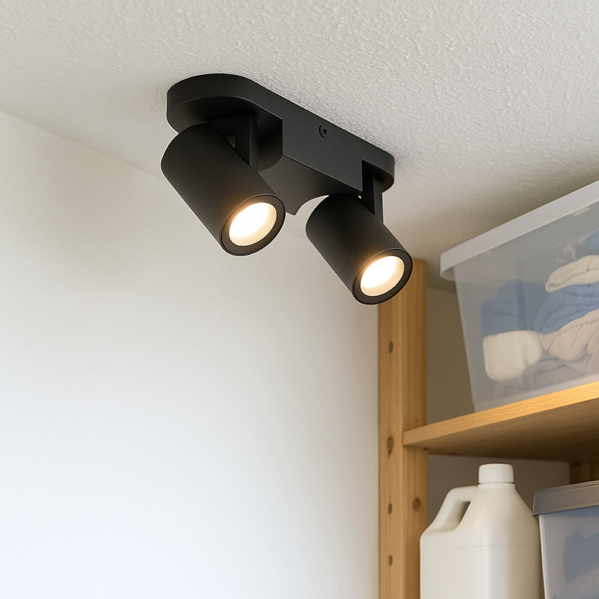 Black ceiling light fixture with two lights on a white wall.
