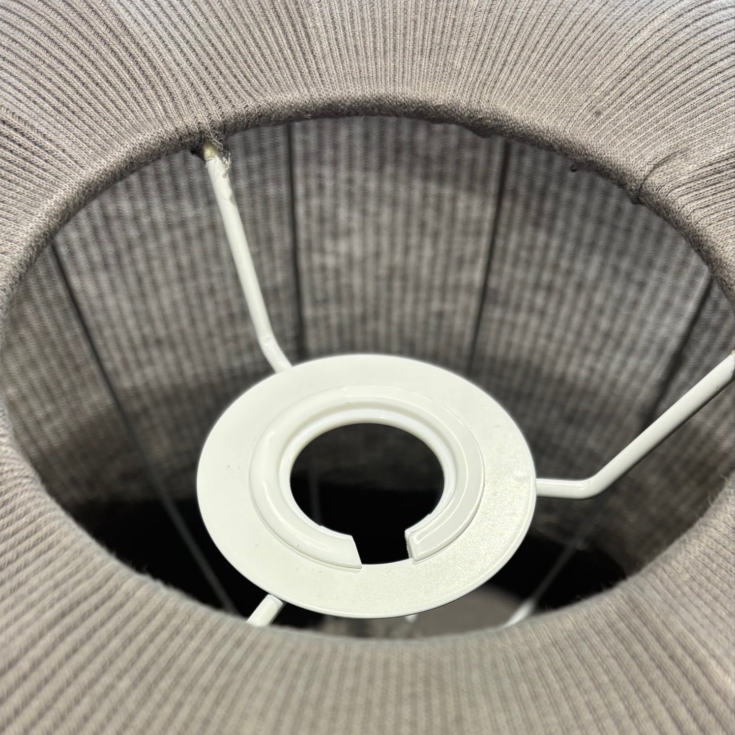Close-up of a gray woven basket with a white circular object inside.