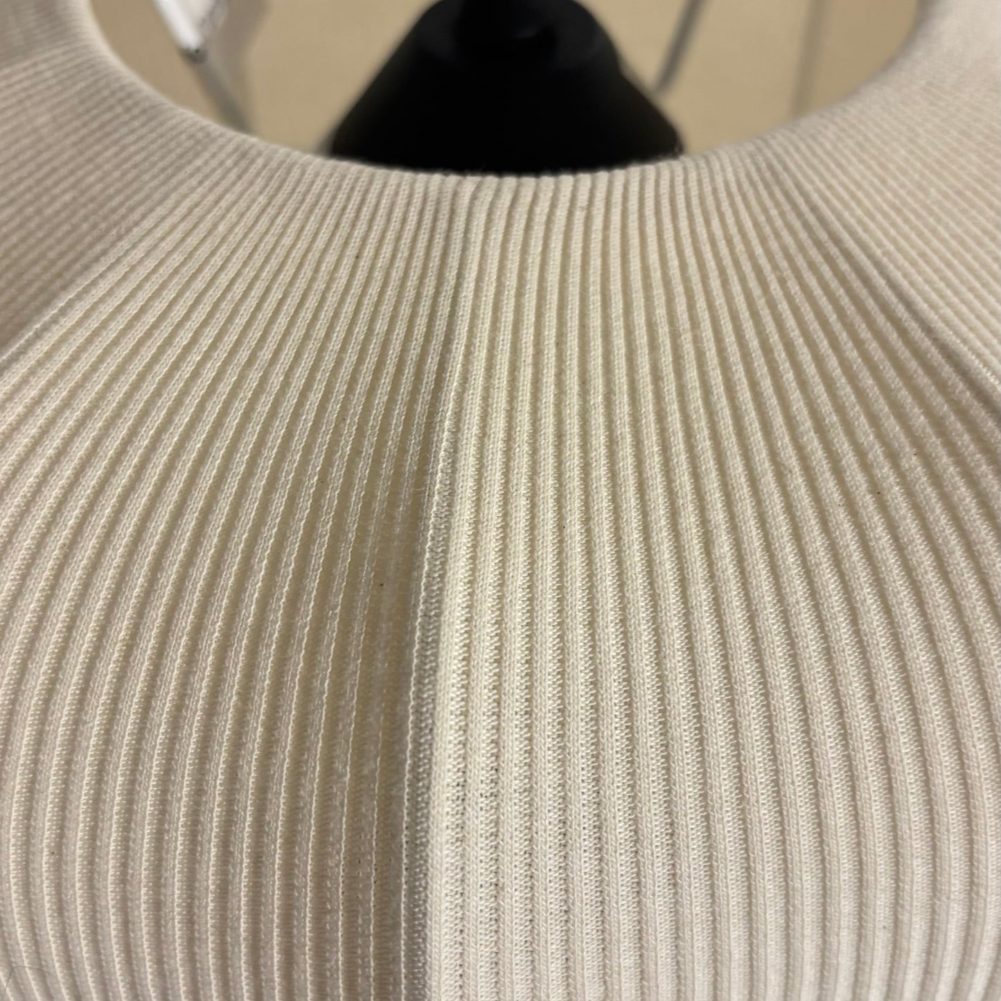 Close-up of a textured beige fabric with a black cord