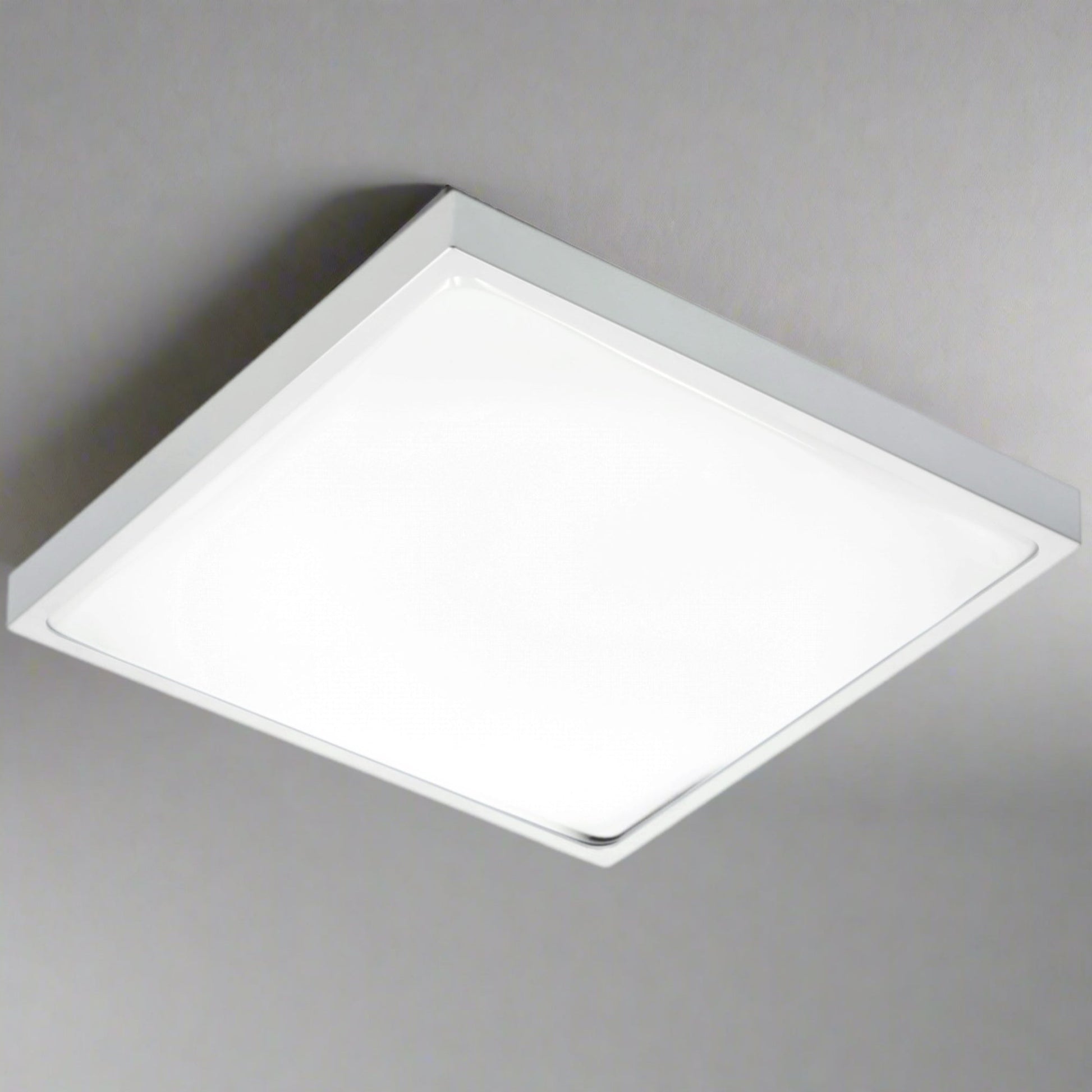 Modern square LED ceiling light with a grey aluminum body and opal diffuser, emitting bright light.