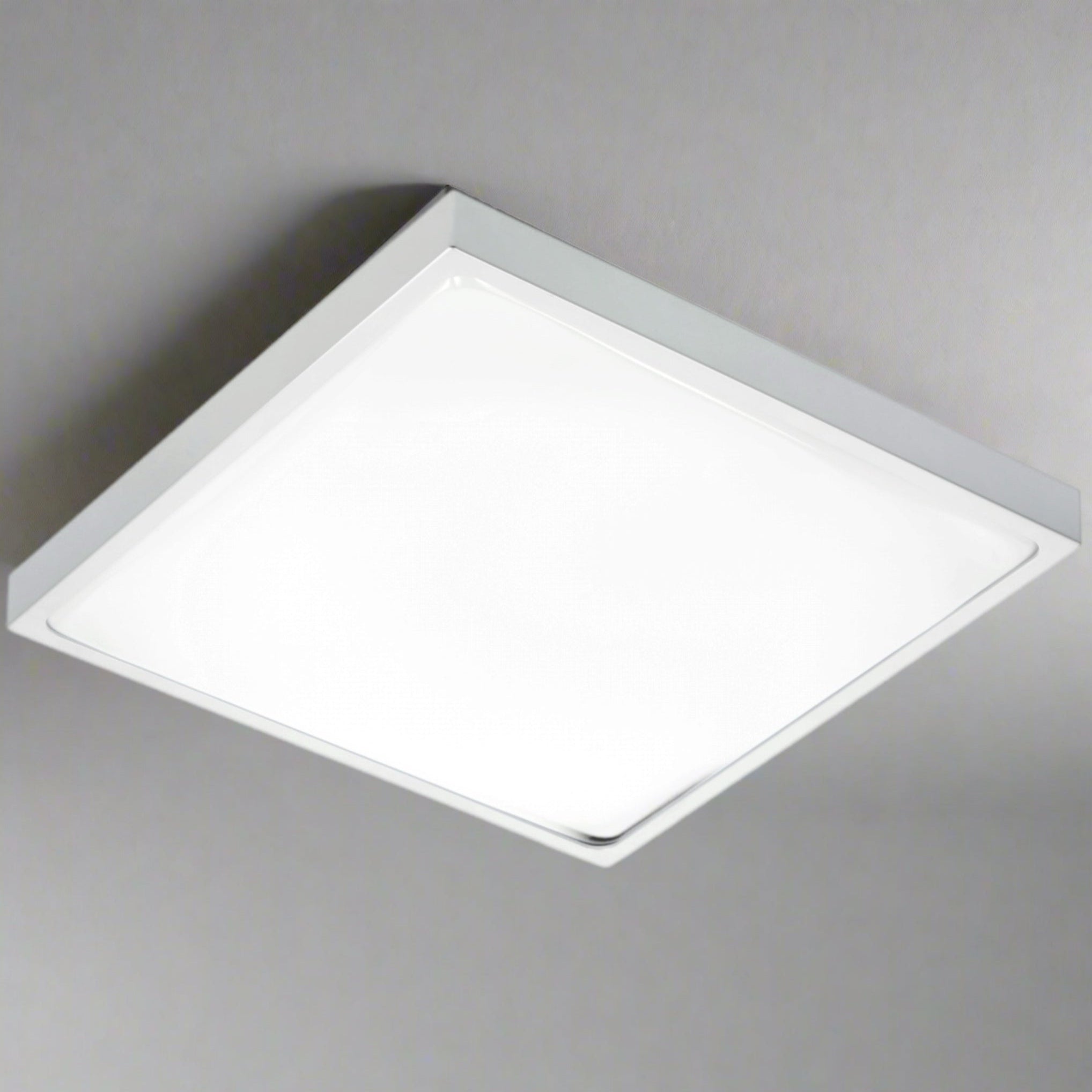 Modern square LED ceiling light with a grey aluminum body and opal diffuser, emitting bright light.