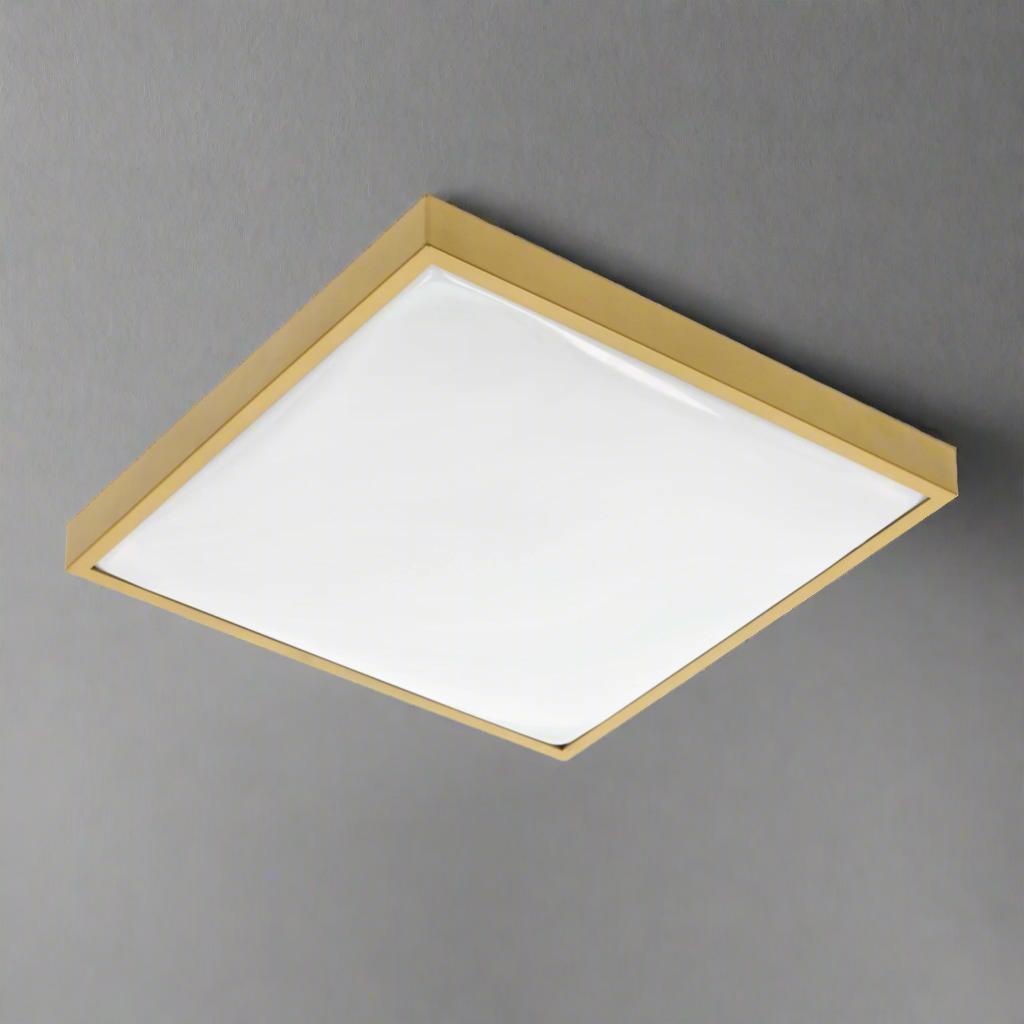 Modern square LED ceiling light with a gold aluminum body and opal polycarbonate diffuser, installed on a gray surface.