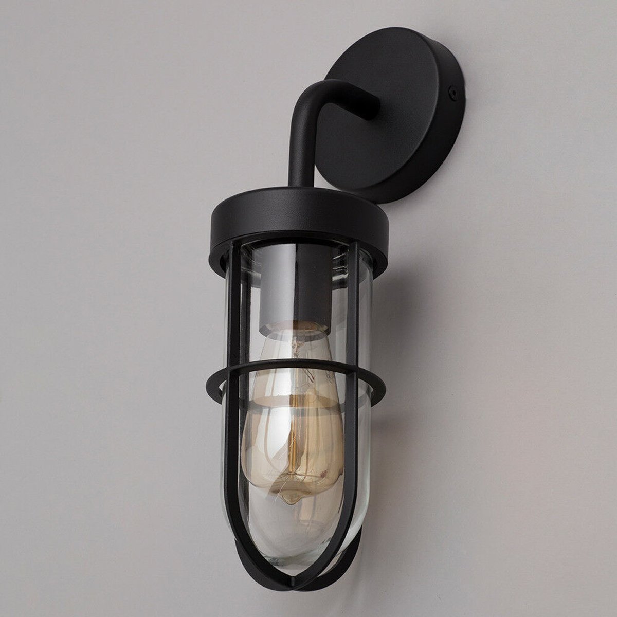 This wall lantern light is styled with a sophisticated black and glass colour scheme, allowing the wall light to fit into any home’s style. What’s more, the lantern’s design is a modern take on a traditional styled wall light, creating a flexible look for interior and exterior use. The addition of the glass shade adds an eloquent appearance when affixed to the wall, ensuring that your home’s looks are not disturbed by our premium wall lantern light.