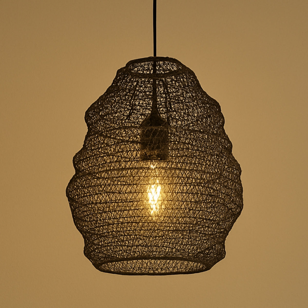 Chrome metal cylinder pendant lampshade with geometric cut-out pattern and inner diffuser, photographed against a grey background.