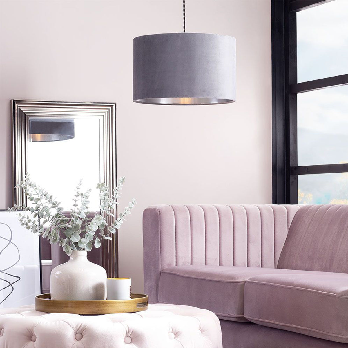 Set of four fabric pendant light shades in neutral and pastel tones hanging in a modern living room.