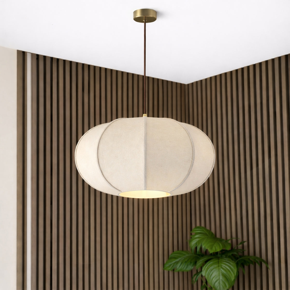 Natural woven ceiling lamp shade hanging above a neutral bedroom with rattan furniture.
