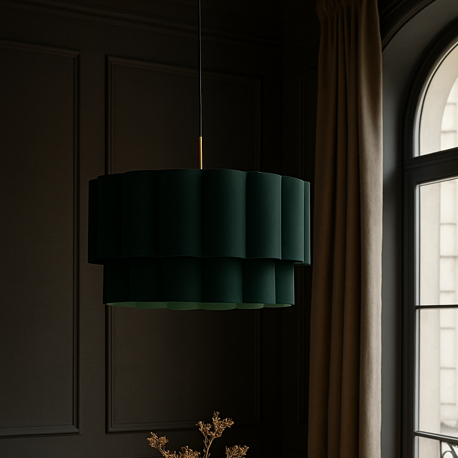 Dining room with a round wooden table, chair, and sofa under a green pendant light.