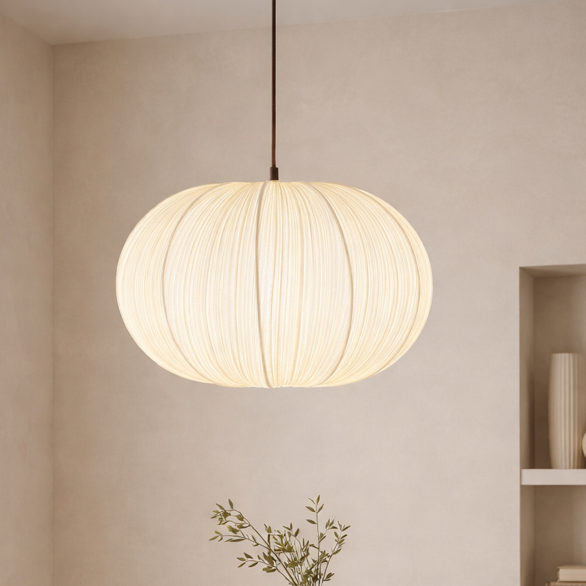 Modern dining room with a round wooden table, chairs, and a pendant light.