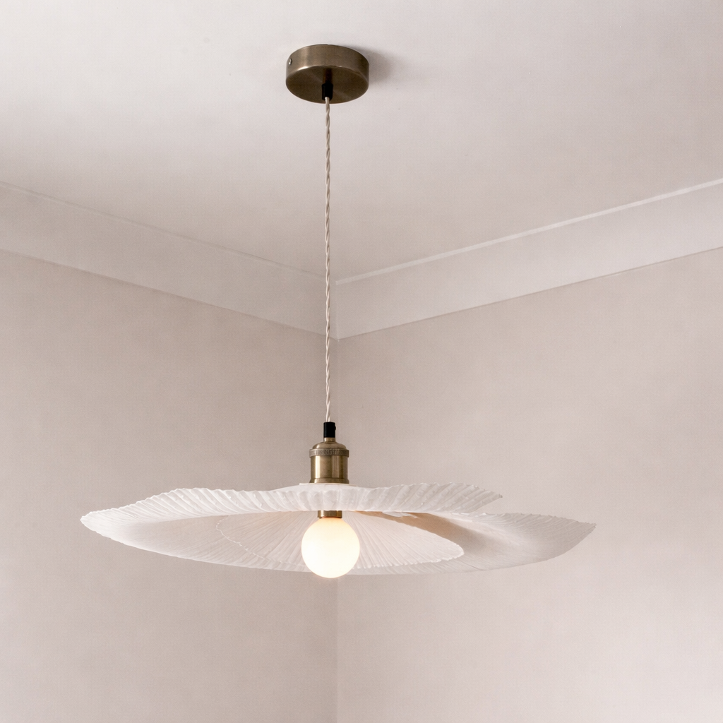 Modern pendant light with a glass shade and brass fixture on a white ceiling.