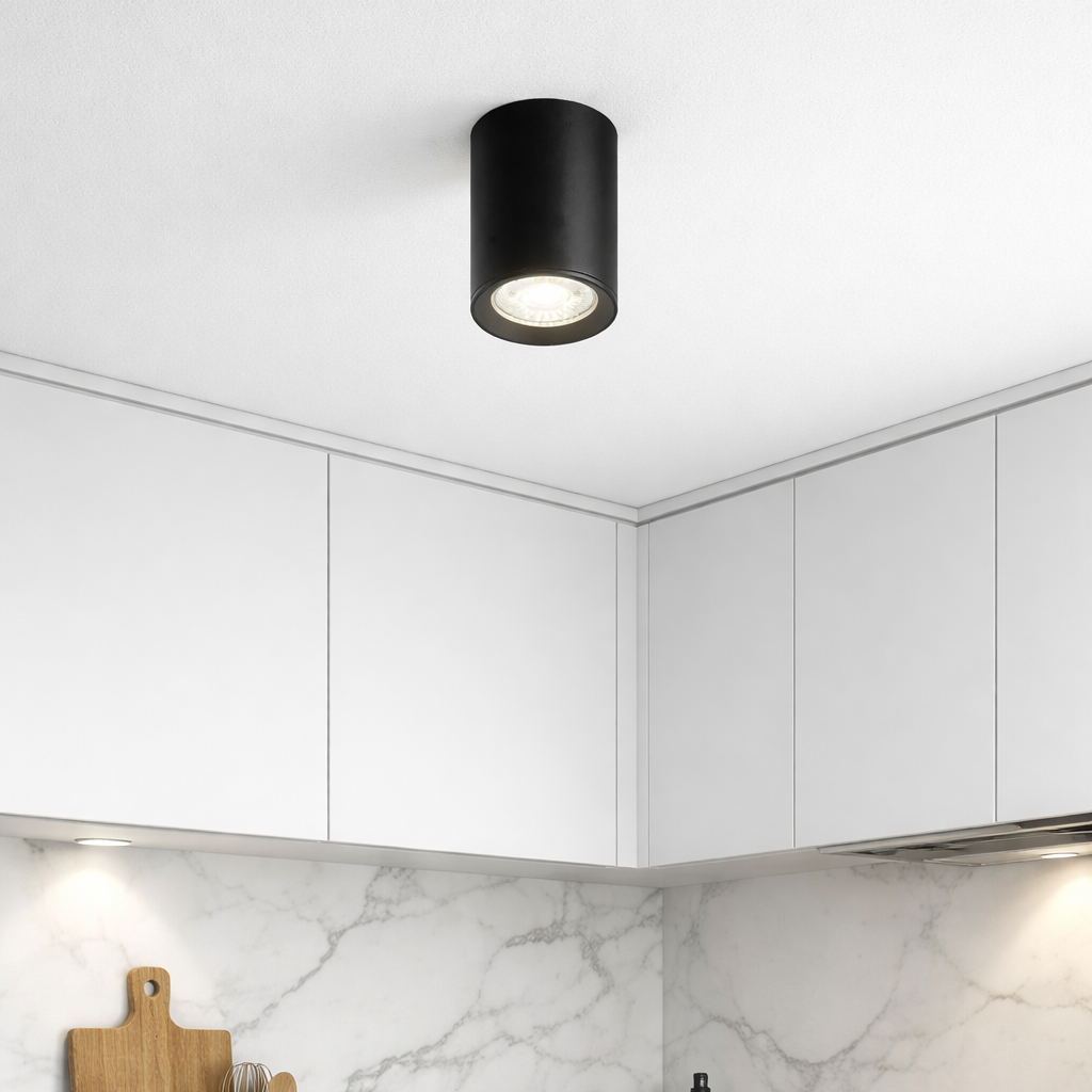 Modern kitchen with white cabinets, marble backsplash, and black ceiling light fixture.