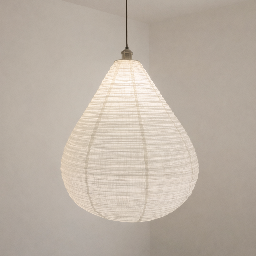 White woven pendant light hanging in a minimalistic room with plain walls and floor.