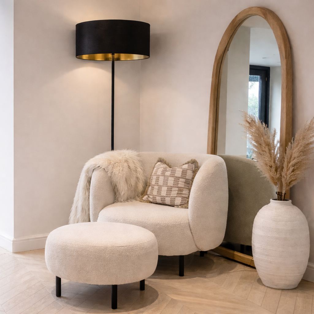 Modern living room with a beige armchair, ottoman, and decorative elements.