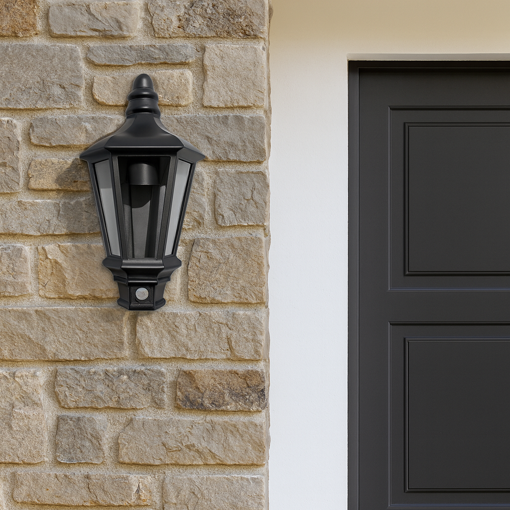 Black outdoor wall light fixture on a stone wall next to a black door.
