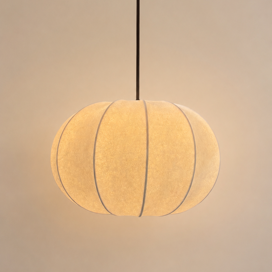 A spherical pendant light with a warm glowing fabric shade, suspended by a thin black cord against a soft beige background.