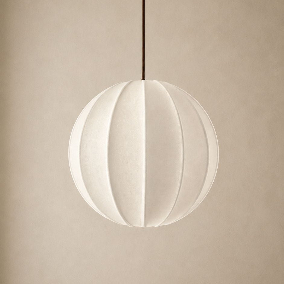 Spherical pendant light with white shade and gold fixture on a beige background