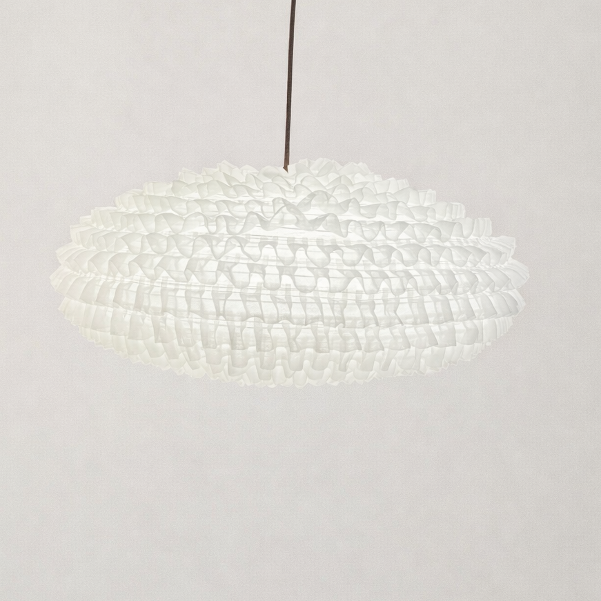 Modern pendant light with a textured shade on a plain background