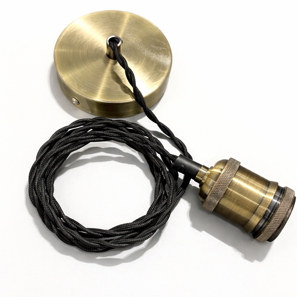 Brass lamp components with black cord on a white background
