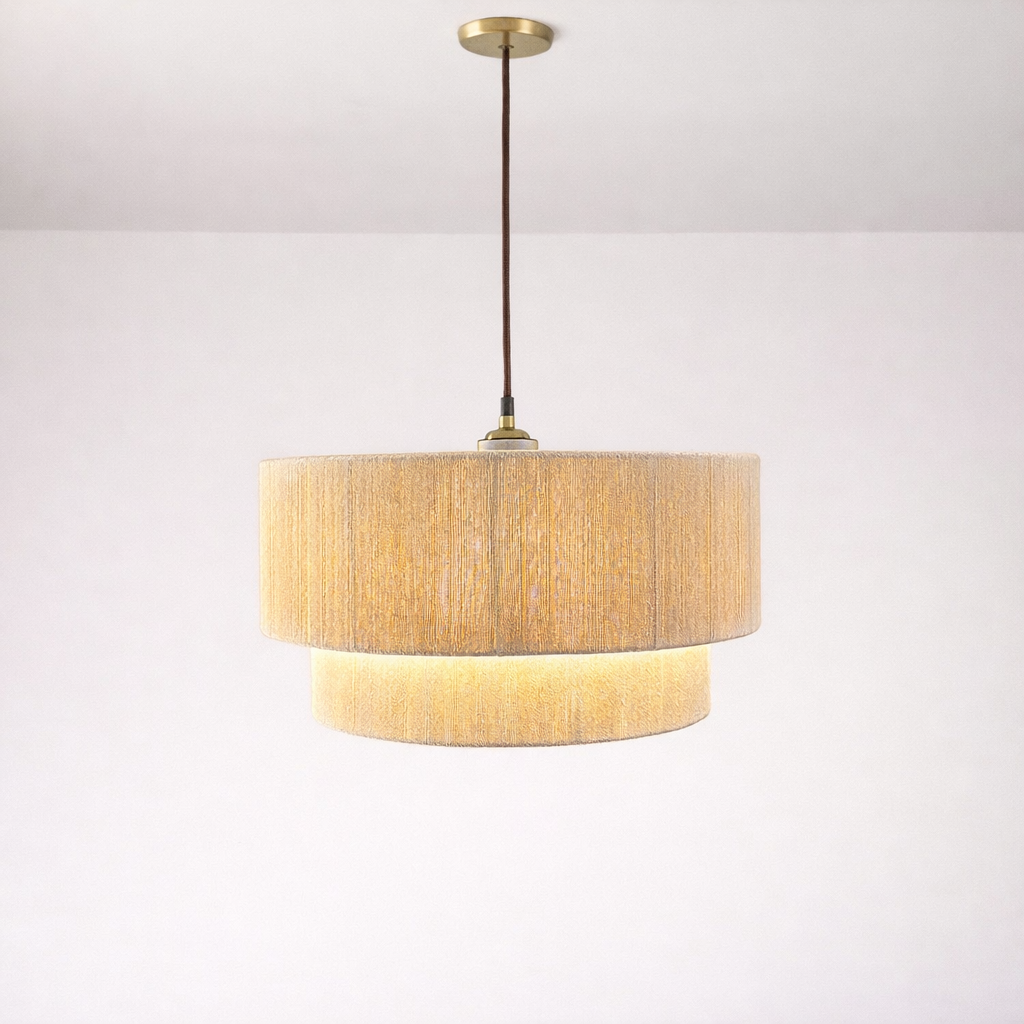 Pendant light with gold finish and textured beige shade on a white background