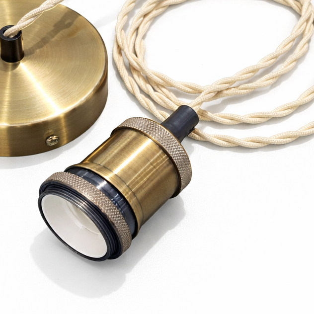 Brass lamp components with a coiled cable on a white background