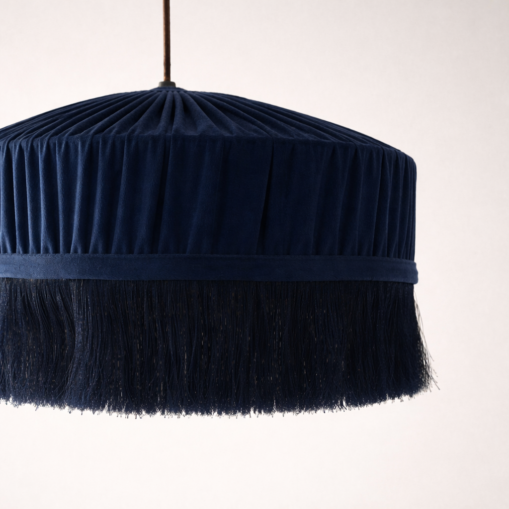 Navy blue pendant light with fringed edge on a white background