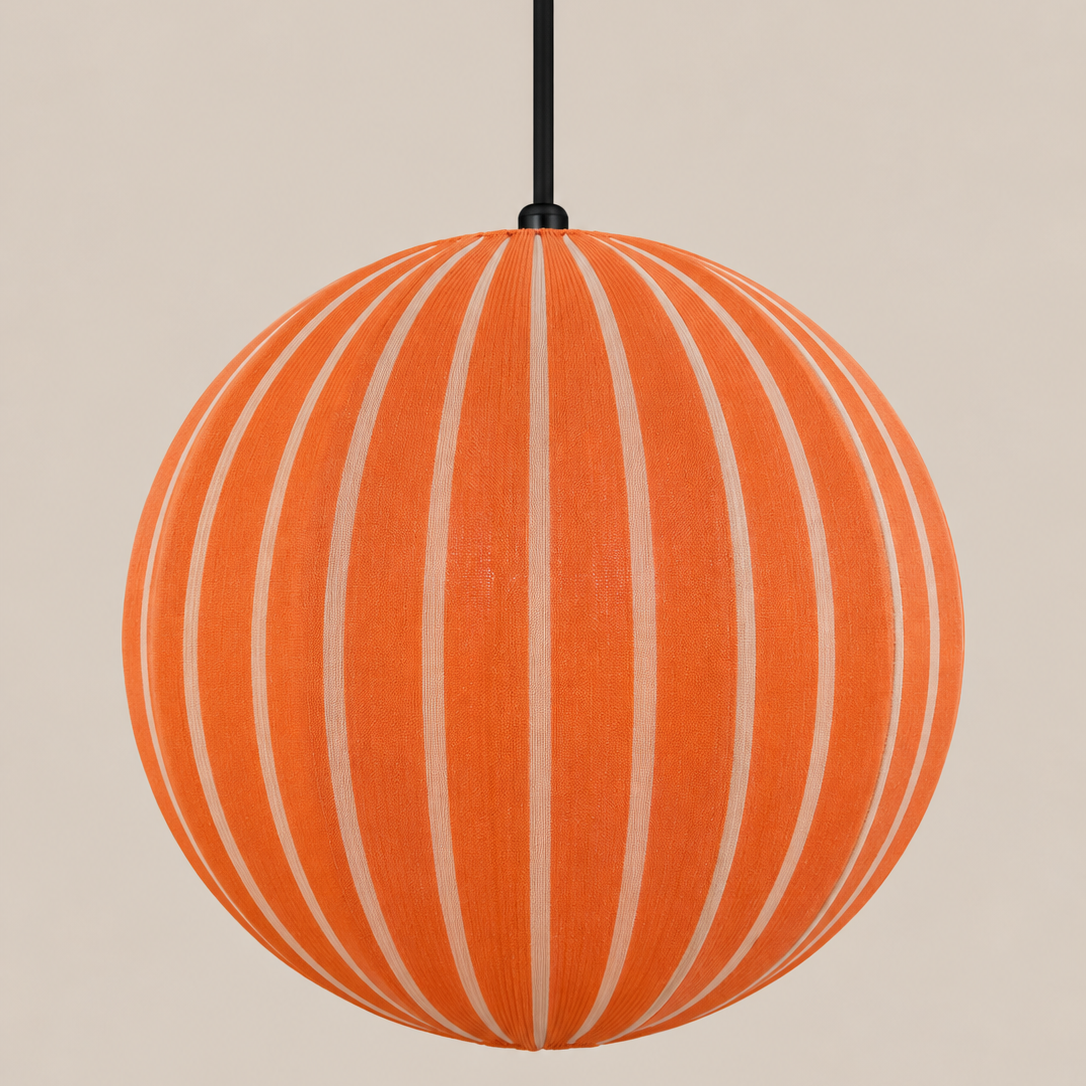 An orange spherical pendant light with vertical cream-colored stripes, suspended by a black cord against a solid beige background.