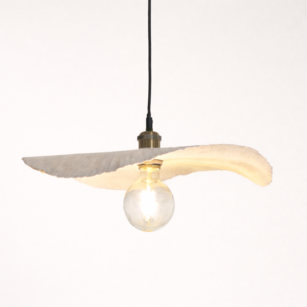 Modern pendant light with concrete shade and exposed bulb on a white background