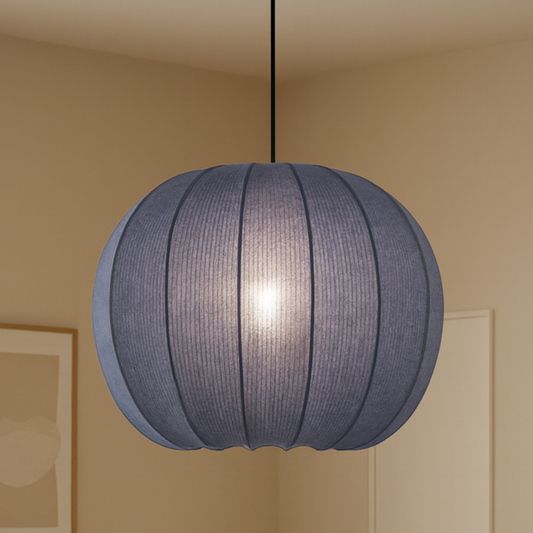 Living room with a blue pendant light, beige sofa, wooden coffee table, and wicker chair.