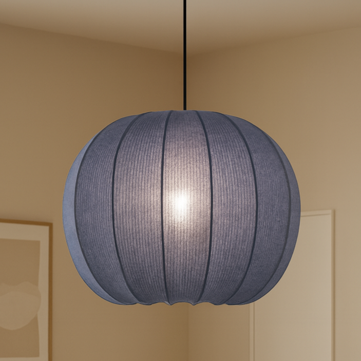 Living room with a blue pendant light, beige sofa, wooden coffee table, and wicker chair.
