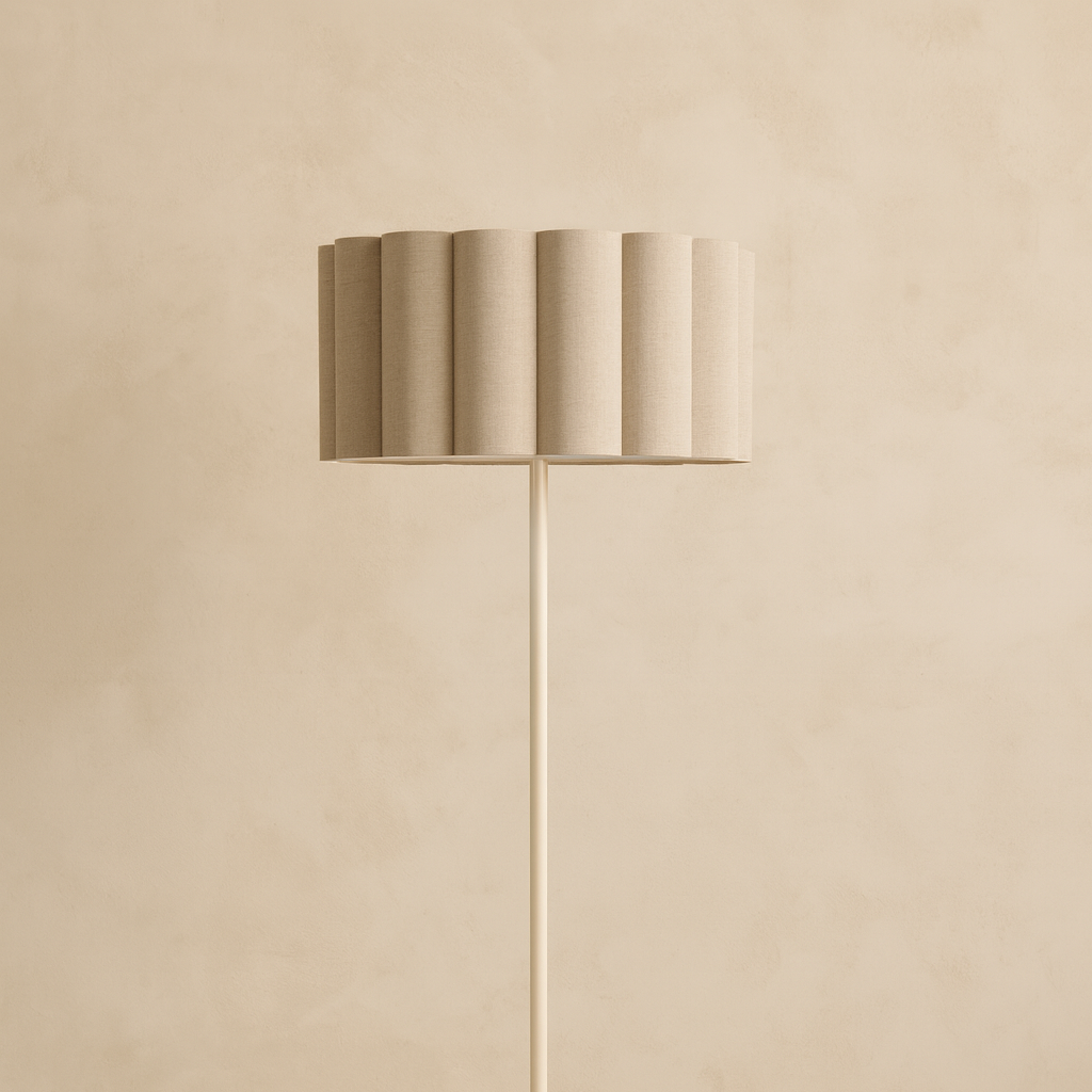 Floor lamp with a beige shade and base against a beige wall.