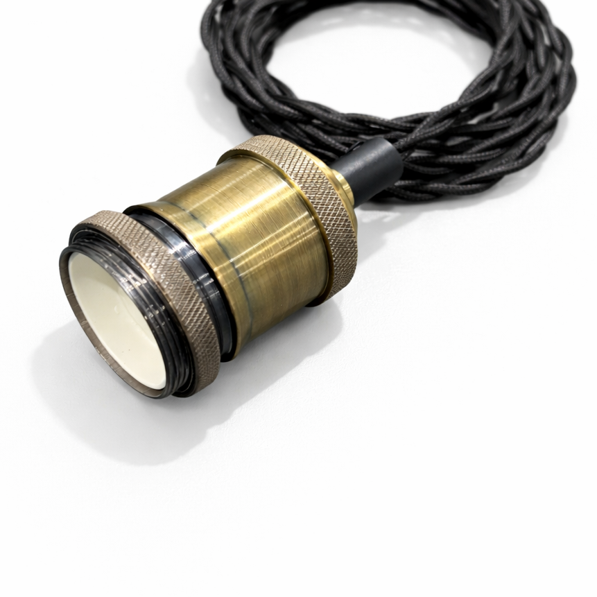 Brass lamp socket with black cord on a white background