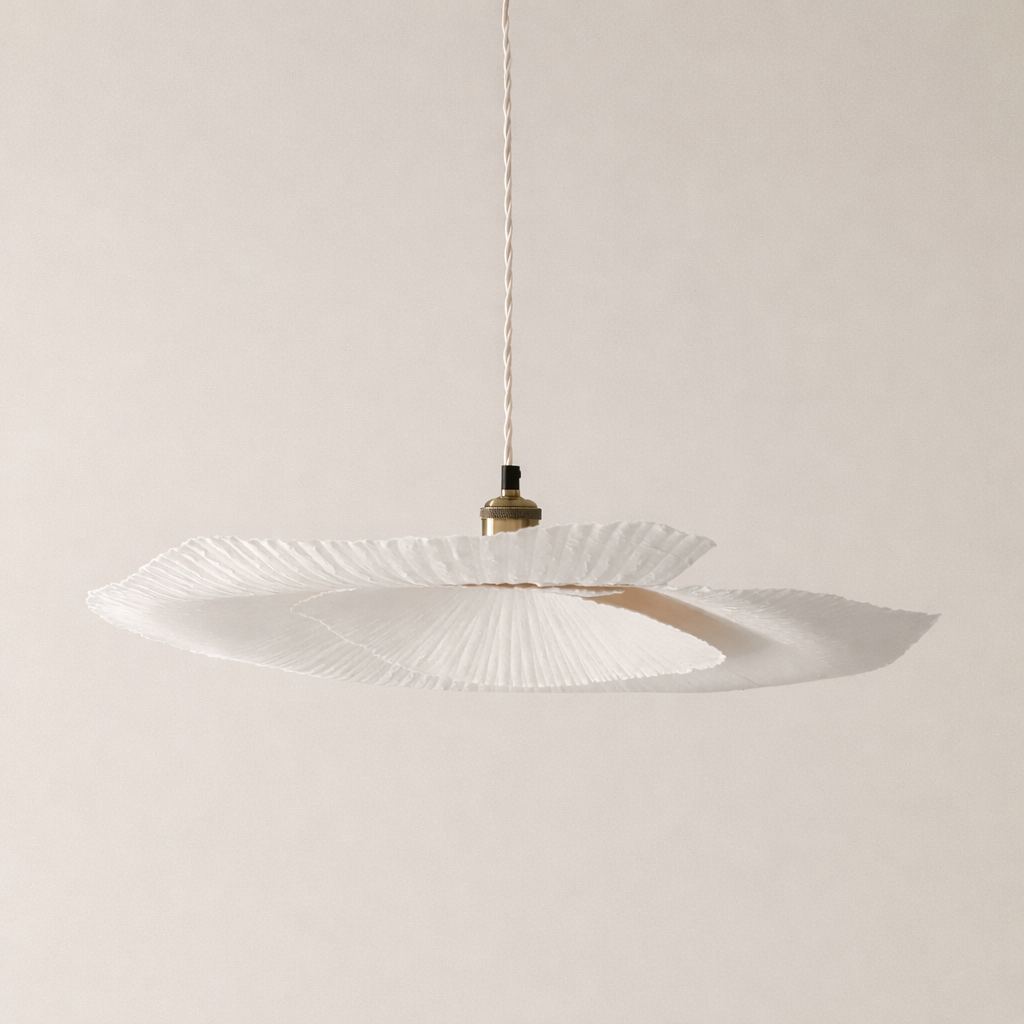 Modern pendant light with white glass shade and gold fixture on a plain background