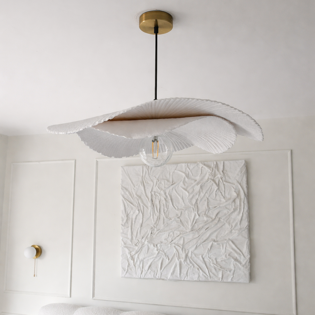 Modern ceiling light fixture in a bedroom with white walls and a textured wall art piece.