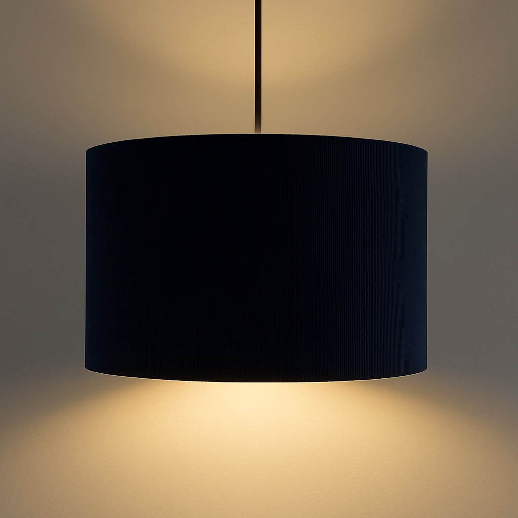 Navy pendant lamp casting a warm glow on a neutral background