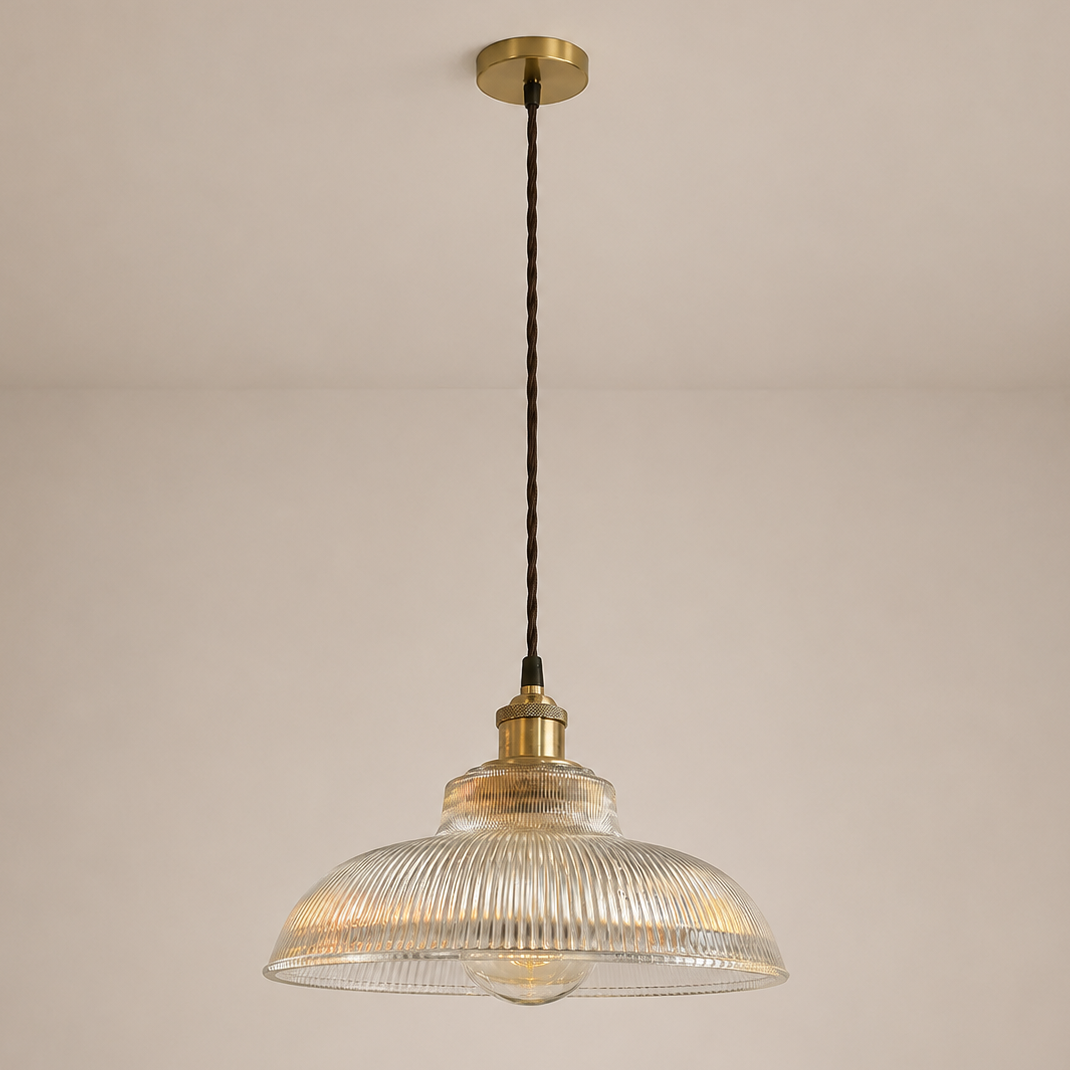 Pendant light with ribbed glass shade and brass fixture on a beige background
