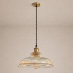 Pendant light with ribbed glass shade and brass fixture on a beige background