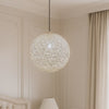 Decorative spherical pendant light in a room with neutral walls and curtains.