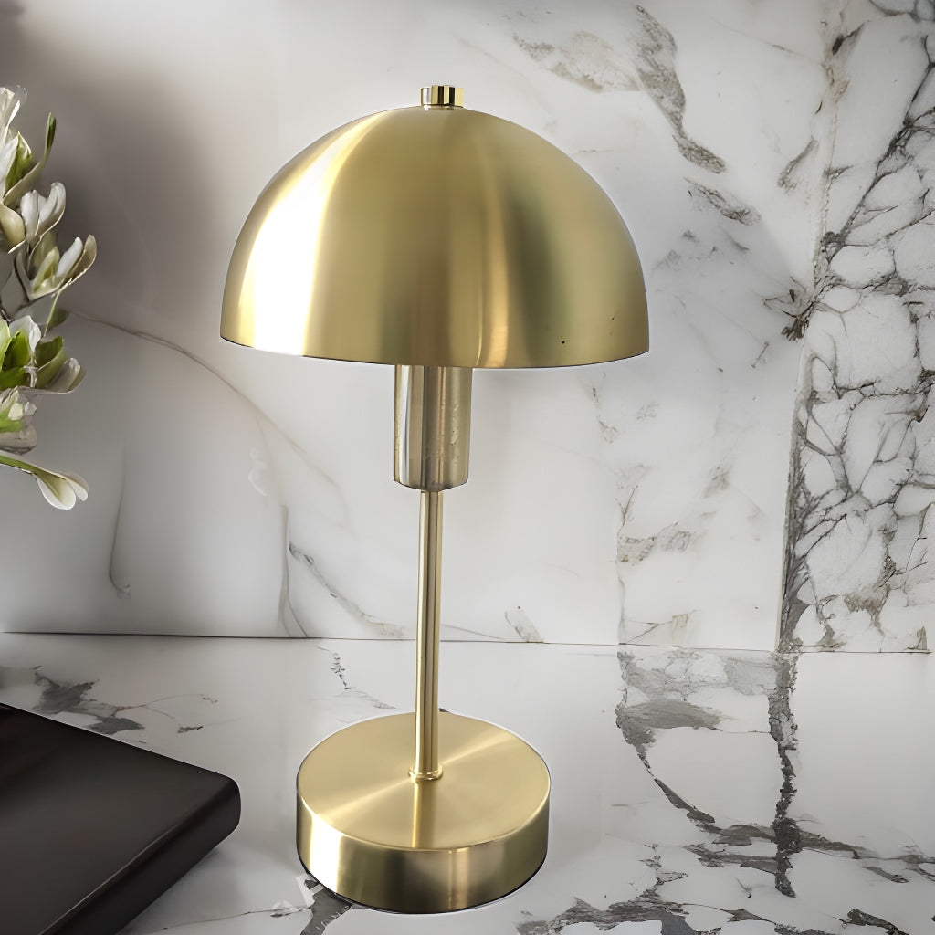 Introducing our Nellie table lamp with its distinctive dome-shaped shade and metal frame, this lamp will become a strong visual element in your space. Thanks to its gold matt antique metal finish, it will suit both modern and Mid-Century inspired settings. Light reflects off the shade to enhance a warm and inviting glow.