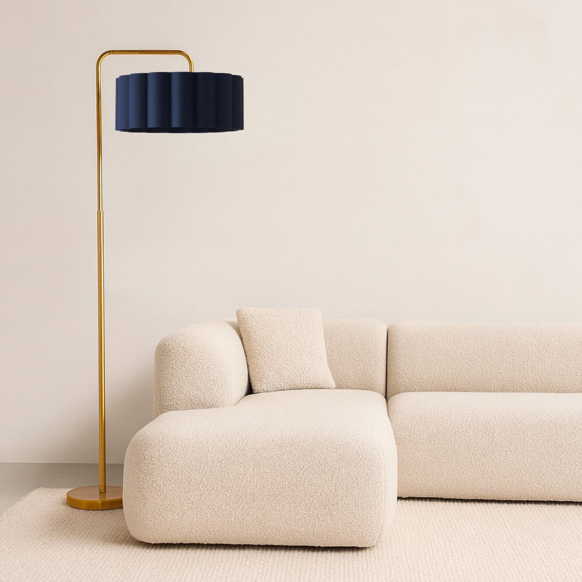 Modern floor lamp with a black shade next to a beige sofa against a plain wall.