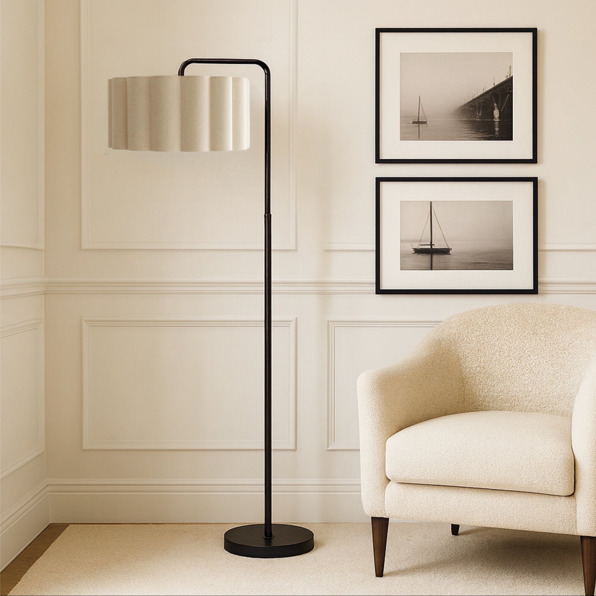 Modern floor lamp with a beige shade in a room with a beige armchair and framed pictures on the wall.