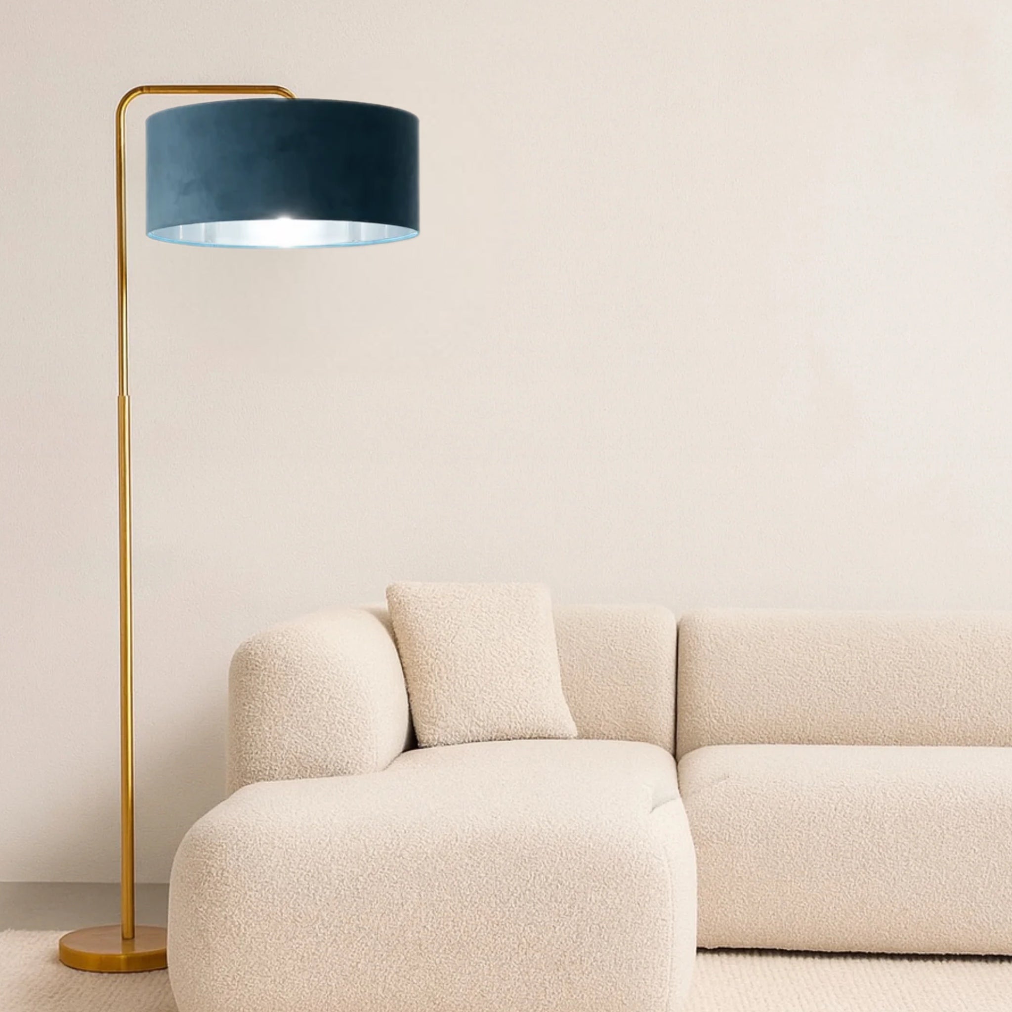 Floor lamp with a blue shade next to a beige sofa against a white wall