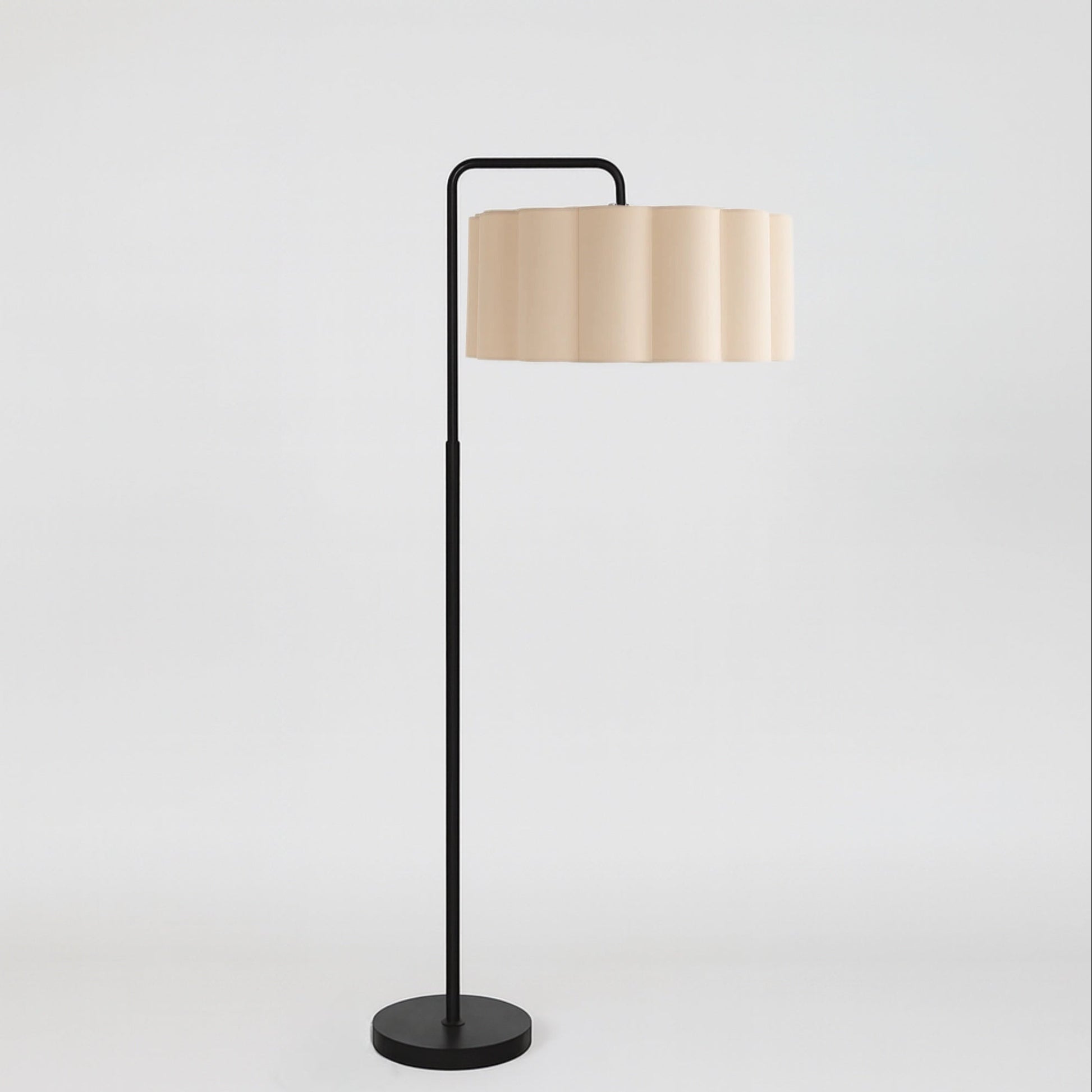 Floor lamp with a beige shade and black base on a light gray background