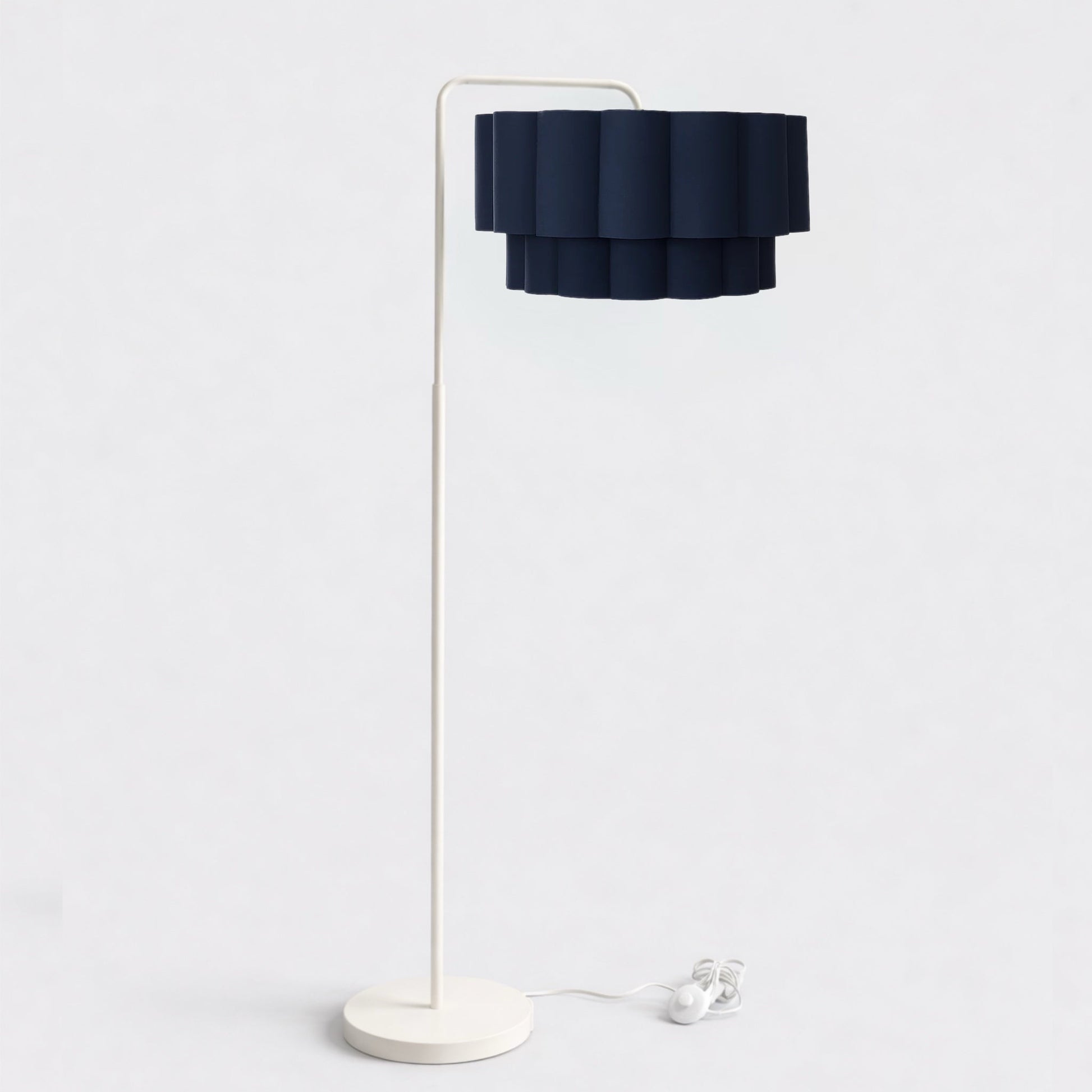 Floor lamp with a dark blue shade and white base on a light gray background