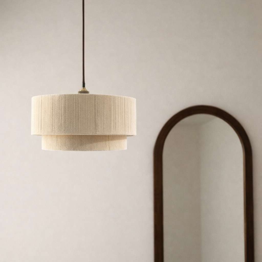 Pendant light fixture hanging above a sofa with a full-length mirror on a white wall.