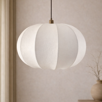 White pendant lamp hanging against a neutral wall with a vase on a shelf.