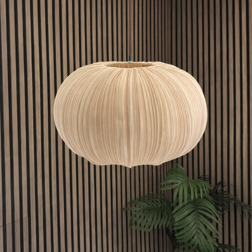 Beige pendant light hanging against a striped wall with a plant in the corner