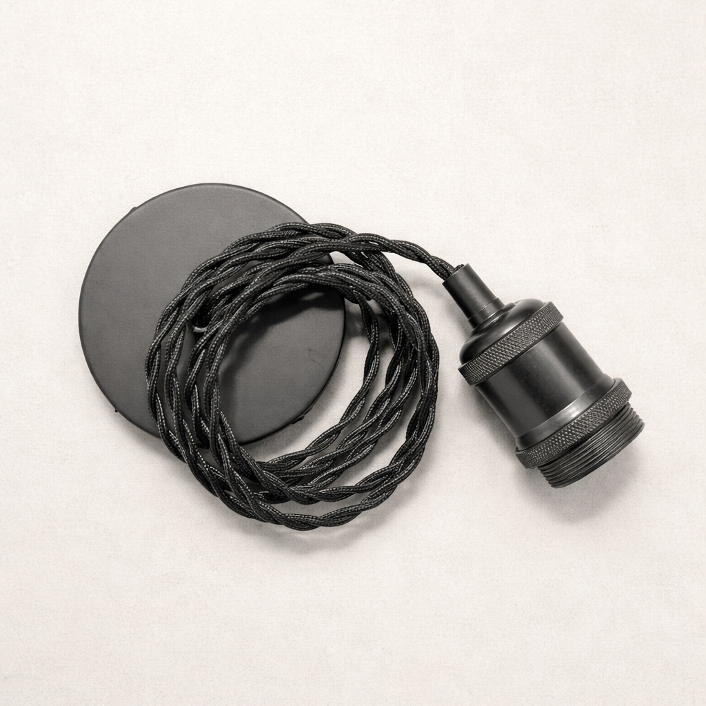 Black lampshade with coiled black cable on a light beige background