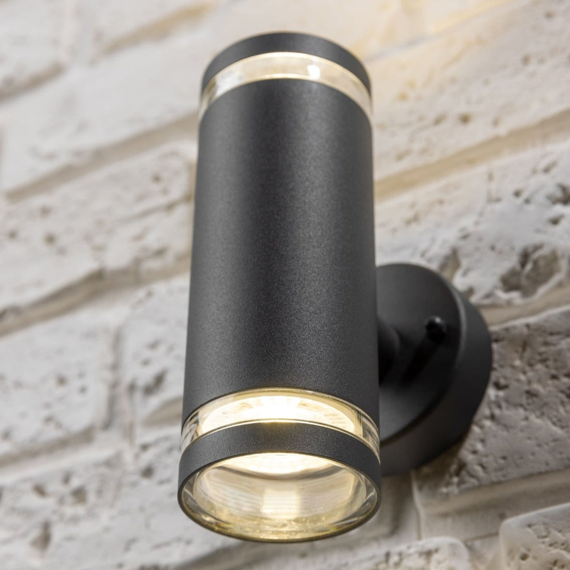 Our Jennifer dark grey outdoor wall mounted up and down cylinder outdoor light would look perfect in a modern or more traditional home design. Outside wall lights can provide atmospheric light in your garden, at the front door or on the terrace as well as a great security solution. It is designed for durability and longevity with its robust material producing a fully weatherproof and water resistant light fitting