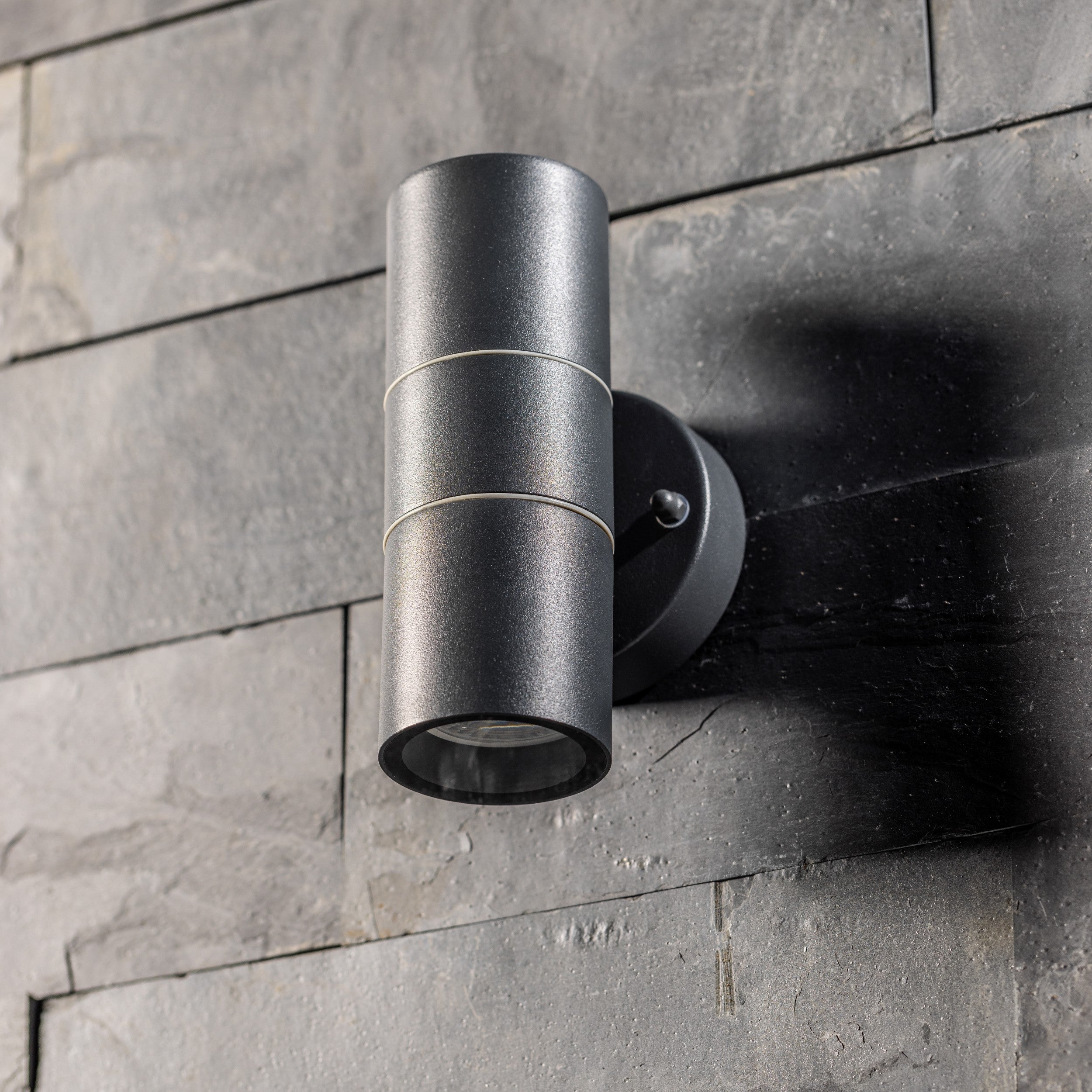 Our Mia outdoor up and down outdoor wall light is modern and stylish in its appearance.  It comes in a cylinder design mounted on a circular back plate and complete with clear glass diffusers. It is designed for durability and longevity with its robust material producing a fully weatherproof and water resistant light fitting